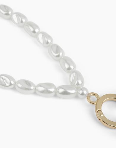Nahaufnahme einer eleganten Halskette mit weißen Perlen und einem goldfarbenen Verschluss