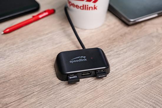 Speedlink Adapter auf einem Schreibtisch neben einem Laptop und einem Kaffeebecher