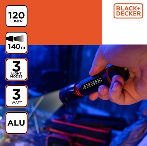 Hand hält BLACK+DECKER Taschenlampe mit 120 Lumen und 140m Reichweite in einem dunklen Raum