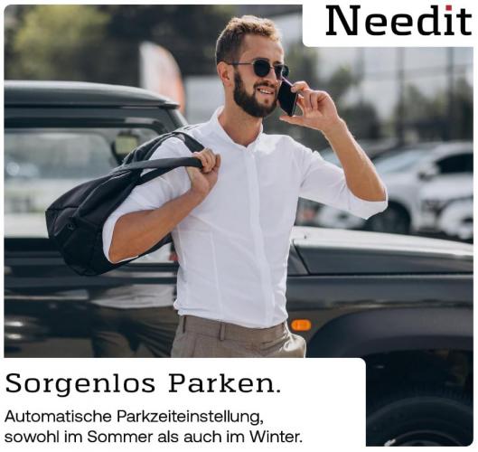 Mann im weißen Hemd telefoniert vor einem geparkten Auto