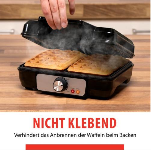 Waffeleisen mit zwei goldbraunen Waffeln, halb geöffnet und dampfend, zeigt Antihaft-Eigenschaften