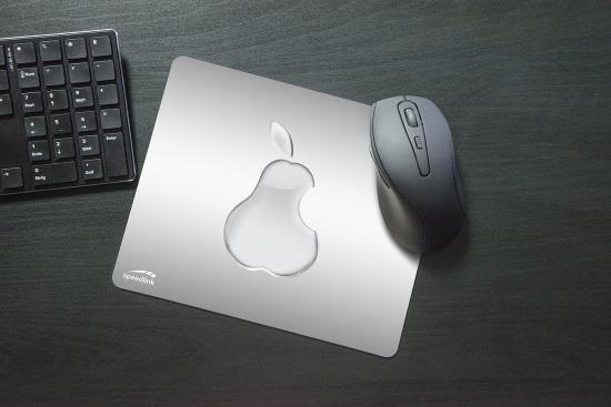 Mauspad aus Metall mit einem Apfelmotiv und kabellose Maus neben Tastatur auf Schreibtisch