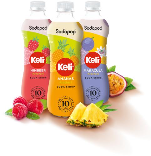 Drei Flaschen Keli Sodapop Sirup in den Geschmacksrichtungen Himbeer, Ananas und Maracuja mit passenden Früchten
